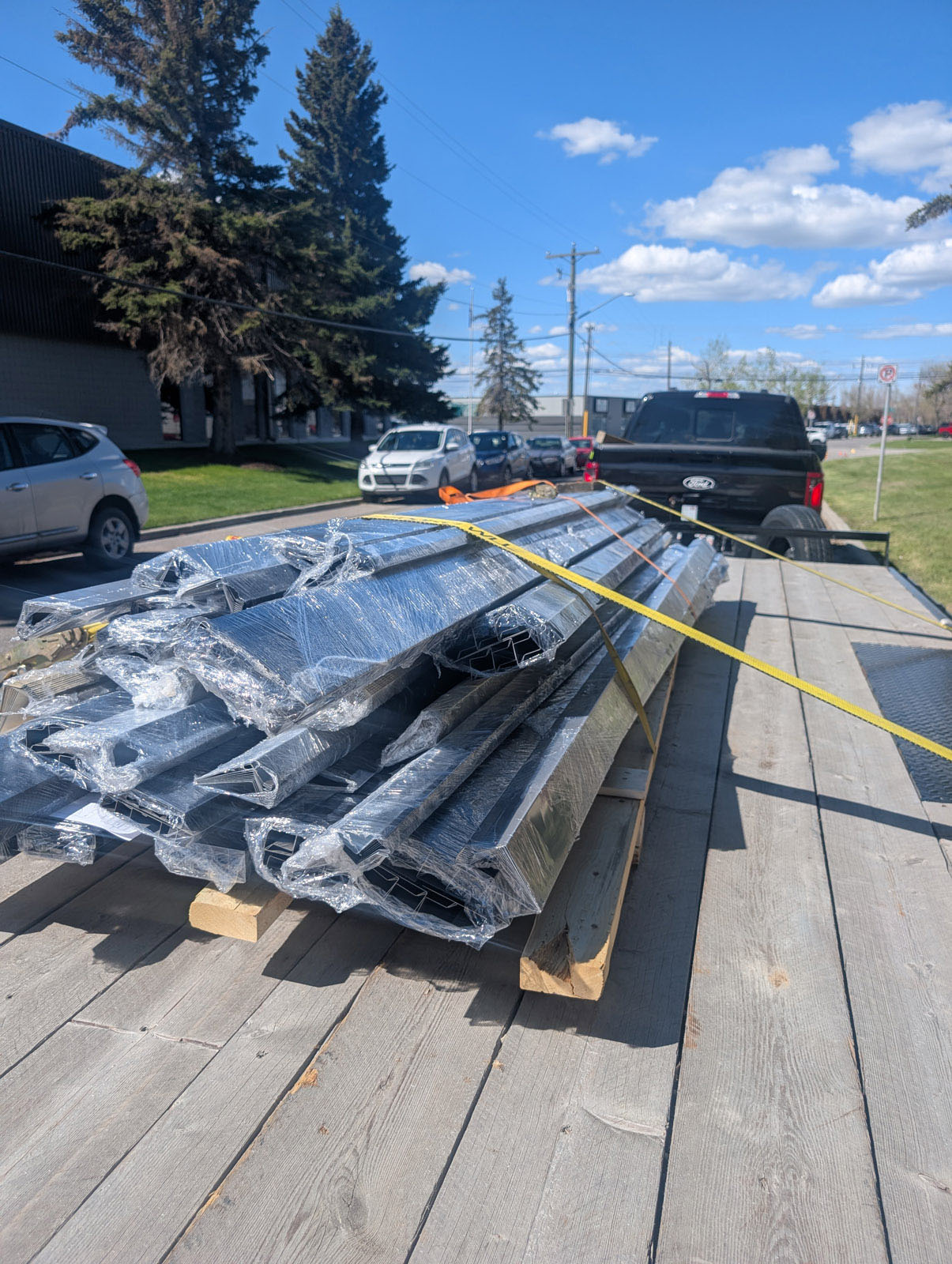 Commercial metal materials secured on a flatdeck trailer for transport.